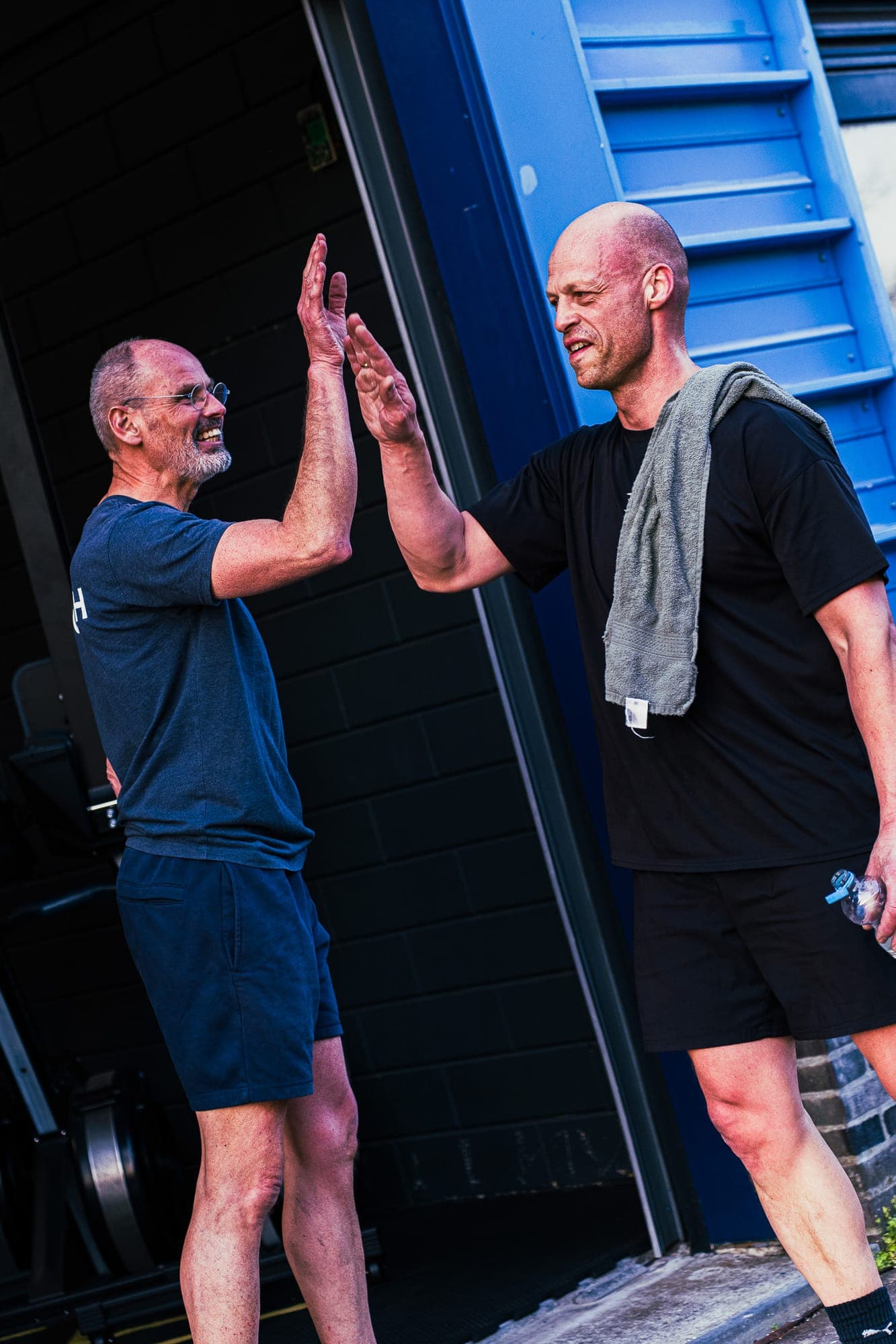 Coach en lid lachen samen voor de WOD
